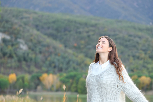 Happy girl breaths fresh air in the mountain - Фото, изображение