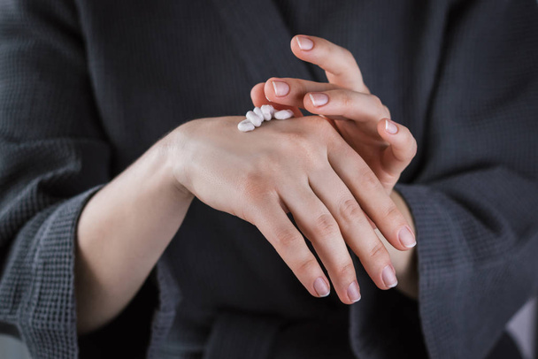 Крупним планом жіночі руки наносять крем для рук. Фон для спа
. - Фото, зображення