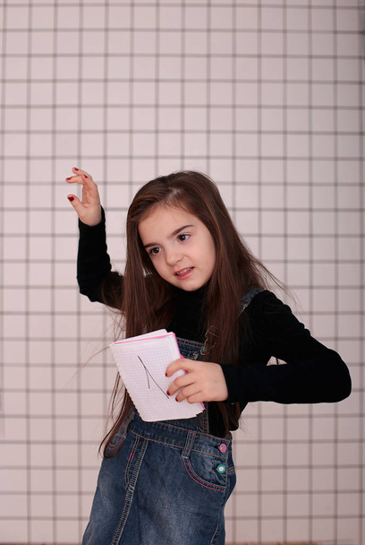 黒のタートルネックのロングヘアで8歳の若い笑顔の女の子と「 1 」の看板のデニムサンドレス" - 写真・画像