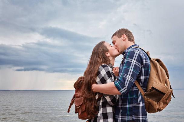 湖畔でキスするハイカーのカップル - 写真・画像