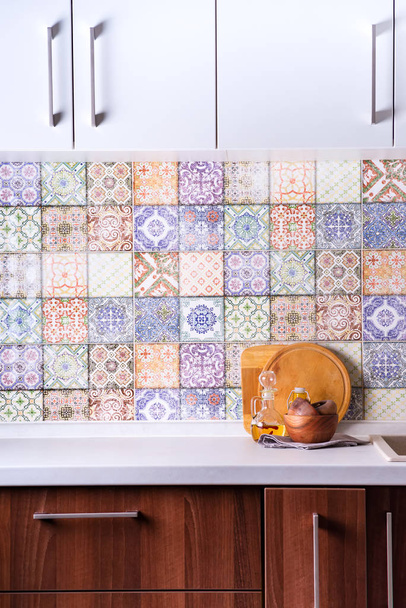 tigelas de madeira e azeite em uma bancada de pedra em um fundo de azulejos coloridos velhos, interior da cozinha fachada
 - Foto, Imagem