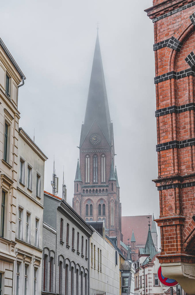 Clock tower of Schwerin Cathedral with heavy fog in Schwerin near Hamburg, Germany - Фото, зображення