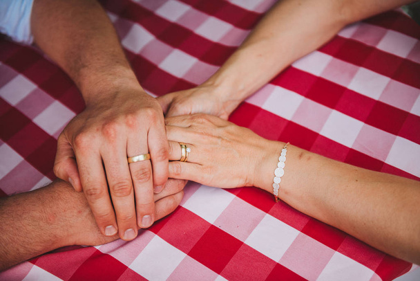Házas pár férfi és nő kéz a kézben jegygyűrűvel - Fotó, kép