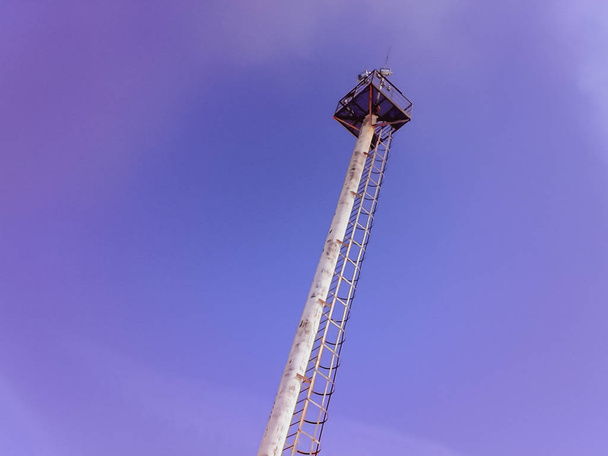 Mast lighting on a blue sky background. Mast with lightning rod and observation platform. - Foto, imagen