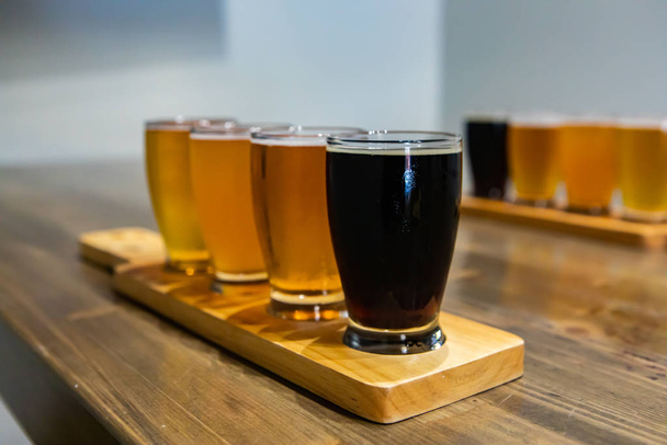 Flight craft beer glasses on wooden tray - Фото, зображення
