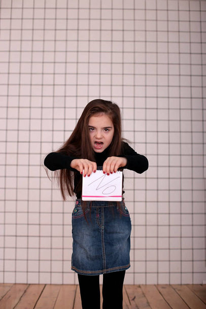 黒のタートルネックのロングヘアで8歳の若い怒れる女の子と"いいえ" - 写真・画像