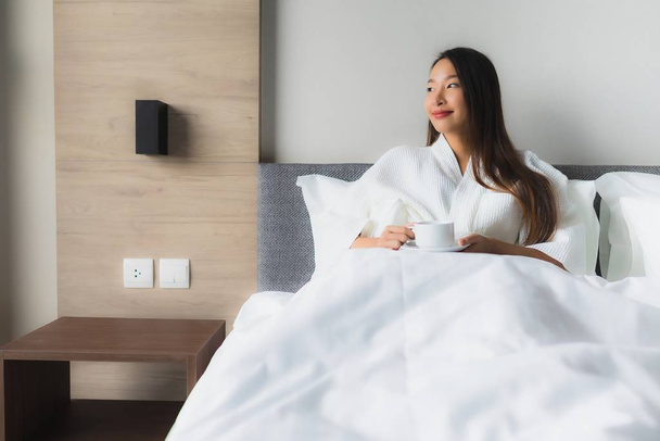 Portrait belles jeunes femmes asiatiques avec tasse de café sur le lit
 - Photo, image