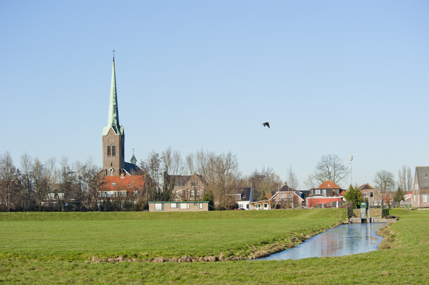 堤防に対して典型的なオランダの村の風景 - 写真・画像