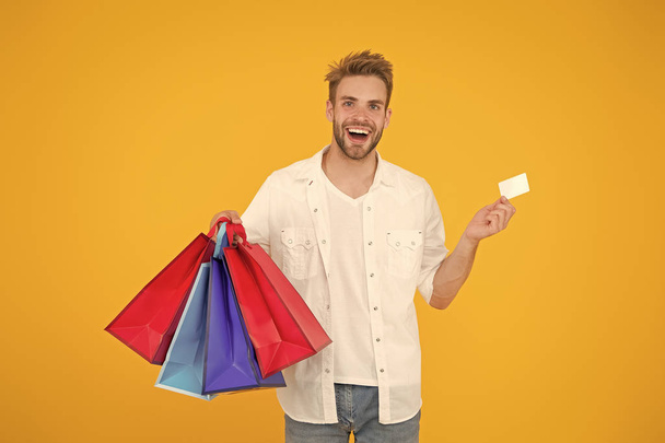 Big discount. Great choices great purchases. Happy man holding purchases in paper bags. Cheerful client customer consumer smiling with fashion purchases. Impulse purchases. Consumerism concept - Fotografie, Obrázek