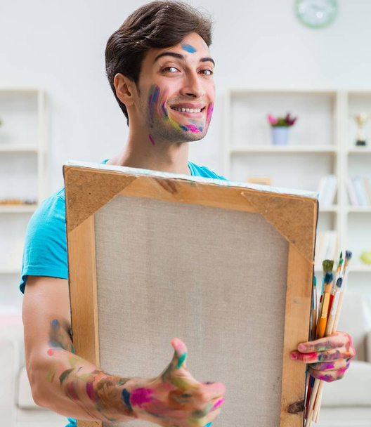 Mladý zábavný umělec pracující na nové malbě ve svém studiu - Fotografie, Obrázek