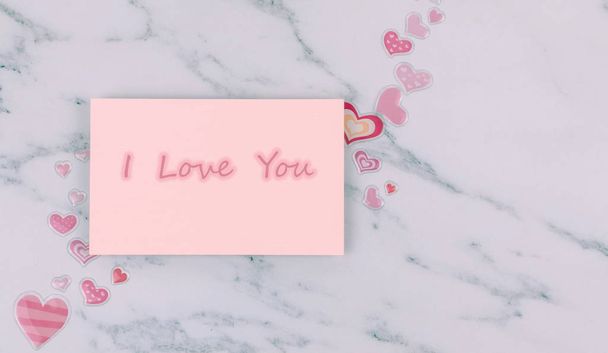 Pastel aralığında "Seni seviyorum" yazılı not kartı ve beyaz mermer arka planda fotokopi alanı olan minik sevimli kalpler. Romantik bir çiftin, sevgilisinin ve sevgilisinin kavramsal görüntüsü. Aşk çerçevesi fotoğrafı. - Fotoğraf, Görsel