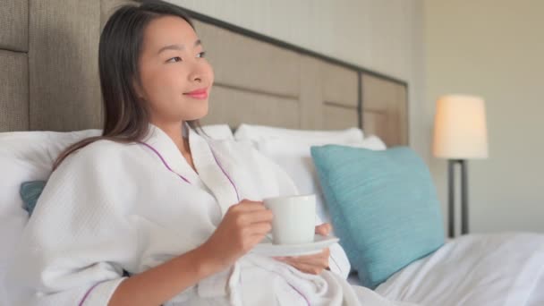 Filmmaterial von schönen asiatischen Frau Kaffee trinken im Bett zu Hause - Filmmaterial, Video