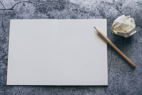 White blank page of notebook, diary or journal with pencil for writing text or message and ideas on concrete background with copy space. Minimalism lifestyle of business and education concept - Photo, Image