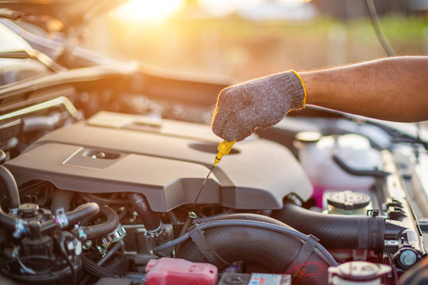 Hand des Technikers, der den Motor des modernen Autos überprüft oder repariert - Foto, Bild