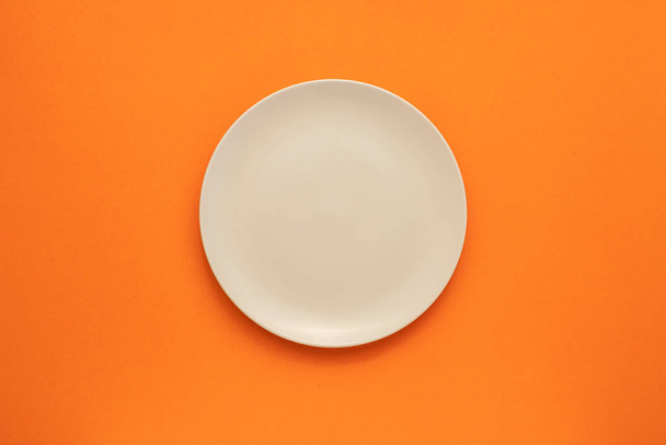 Top view empty white ceramic dish on the middle of orange  - Photo, Image