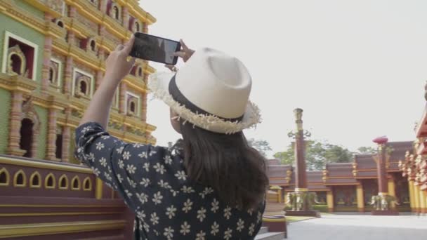 asiatische Touristin fotografiert mit Handy eine große Pagode im buddhistischen Tempel. - Filmmaterial, Video