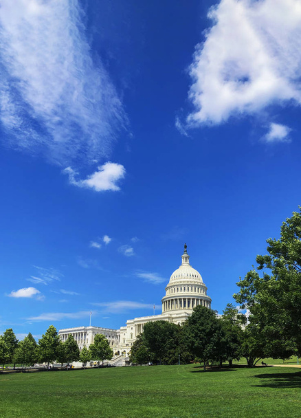 Hauptstadtgebäude der Vereinigten Staaten mit Gras und blauem Himmel. - Foto, Bild
