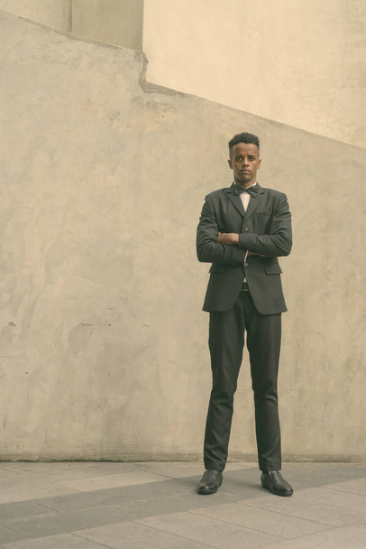 Jovem bonito empresário africano vestindo terno contra parede de concreto ao ar livre
 - Foto, Imagem