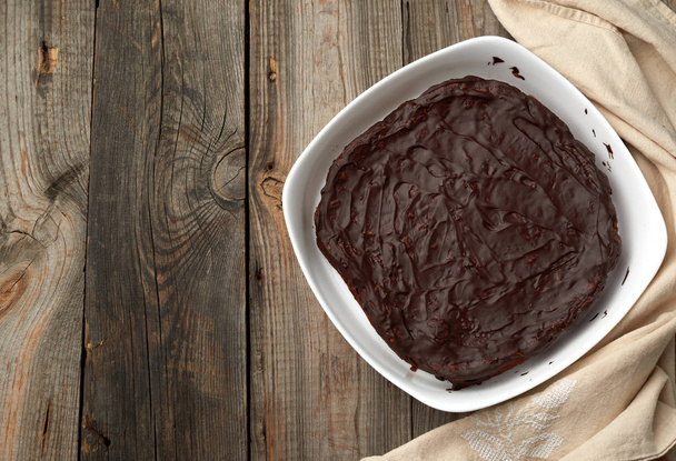 baked brownie chocolate cake in a white ceramic plate on a gray  - Fotografie, Obrázek