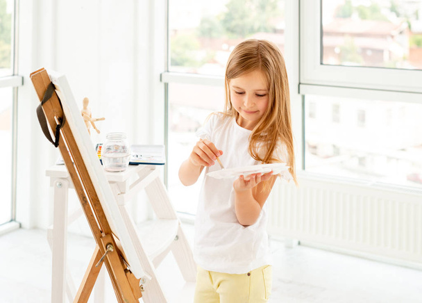 Kid girl drawing with oil paint and palette - Foto, Imagem