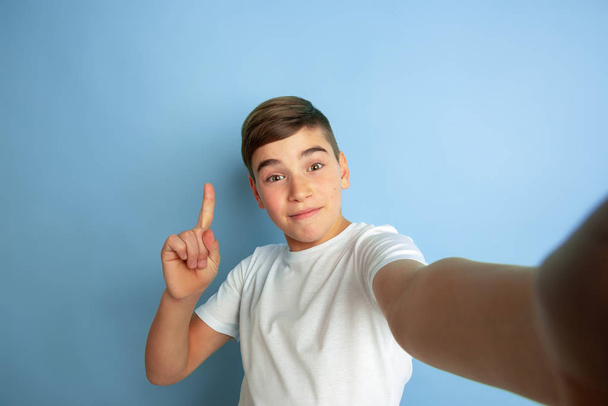 Caucasian teens portrait isolated on blue studio background - Foto, Bild