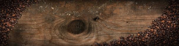 古い木の背景に焙煎されたコーヒー豆 - 写真・画像