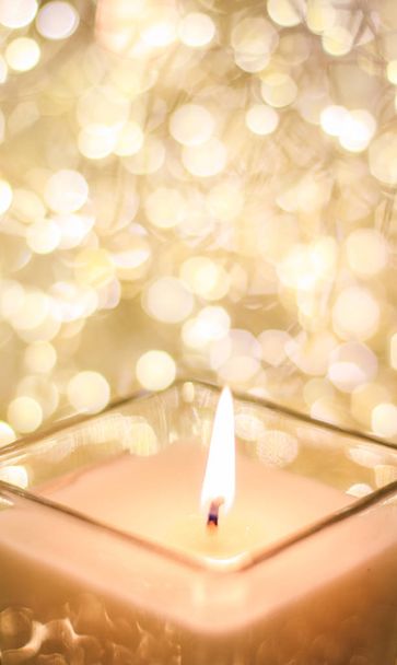 Aromatic candle on golden Christmas and New Years glitter backgr - Photo, Image