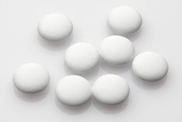 Grupo de píldoras blancas sobre fondo blanco: concepto de salud y medicamentos. Industria farmacéutica. Farmacia
. - Foto, Imagen
