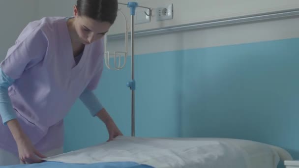 Deskundige verpleegkundige die het bed opmaakt in het ziekenhuis - Video