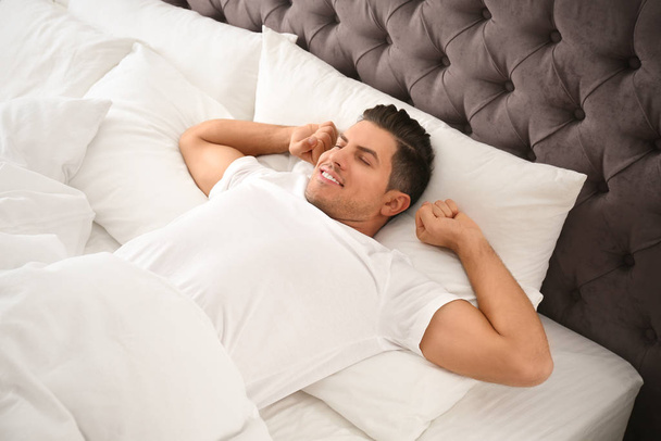 Man awakening on bed at home. Lazy morning - Foto, afbeelding