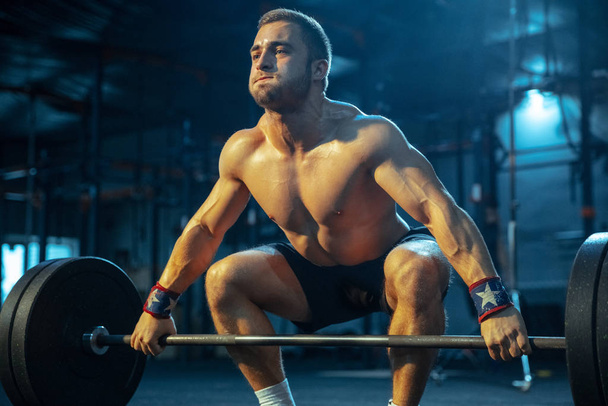 Caucasian man practicing in weightlifting in gym - Zdjęcie, obraz