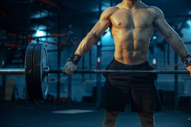 Caucasian man practicing in weightlifting in gym - Фото, изображение