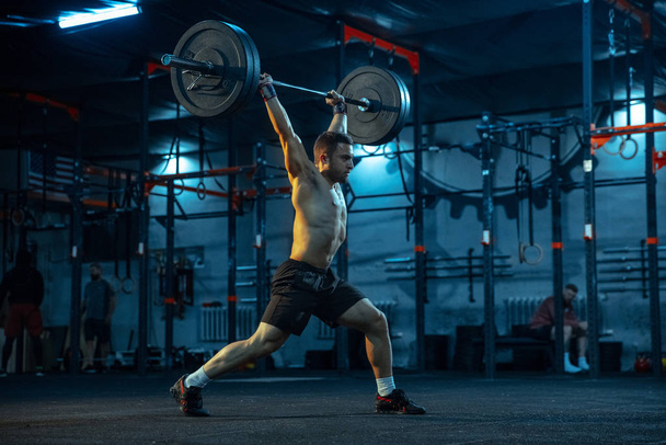 Caucasian man practicing in weightlifting in gym - Foto, Imagen