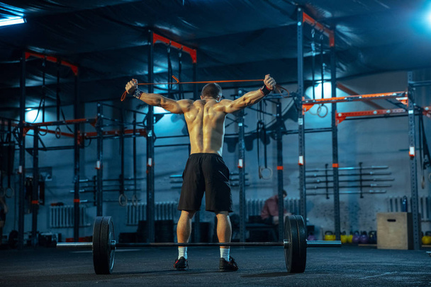 Caucasian man practicing in weightlifting in gym - Foto, imagen