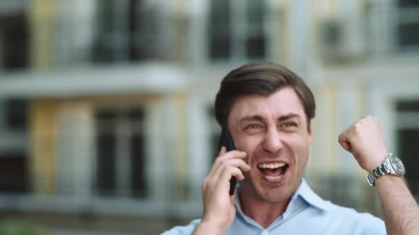 Closeup businessman celebrating victory. Man having phone talk at street - Video