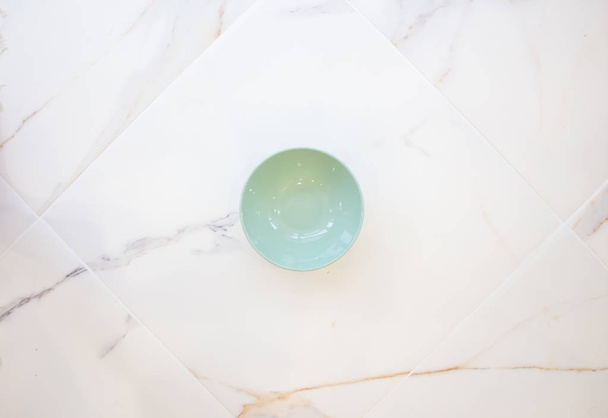 green circle on white marble. space for text. layout. contemporary tableware, marble countertop. - Фото, изображение