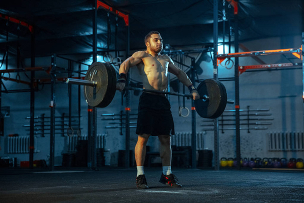 Caucasian man practicing in weightlifting in gym - Photo, image