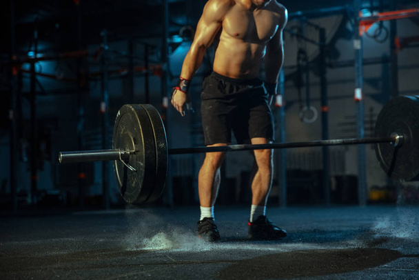 Caucasian man practicing in weightlifting in gym - Fotó, kép