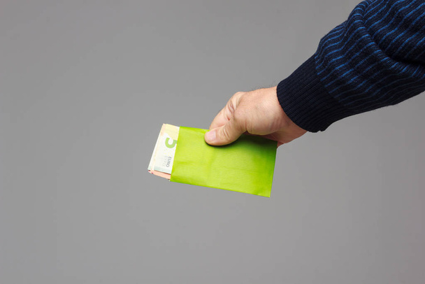 人の手に緑の封筒 - 写真・画像
