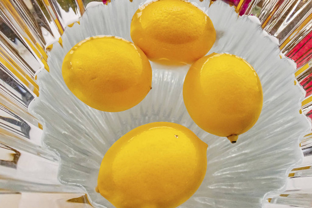 zamknąć żółte cytryny w wodzie w wazonie - Zdjęcie, obraz