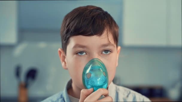 Léčba astmatu, chlapec dýchá přes inhalátor. Stojí v kuchyni - Záběry, video