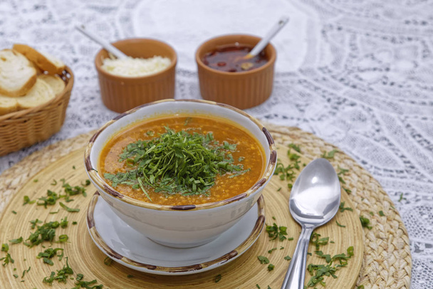 soupe rouge aux lentilles et légumes, légumes verts et herbes avec des morceaux de pain dans le panier avec des sauces
 - Photo, image