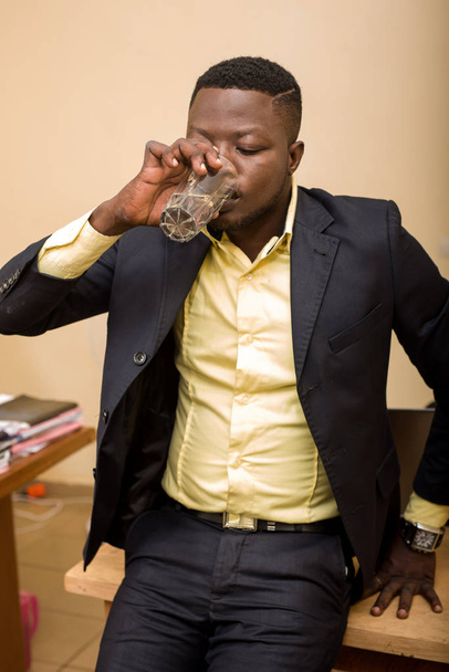 Businessman in office and drinking water - Foto, afbeelding