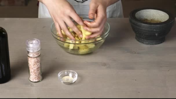 Manos femeninas mezclando patatas crudas con especias
 - Imágenes, Vídeo