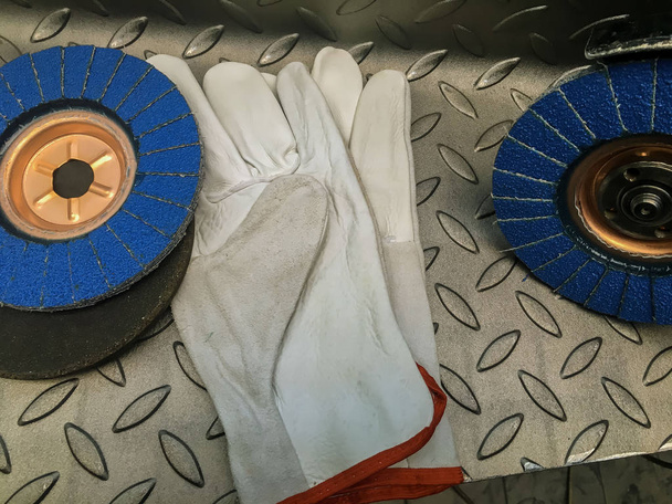 Grinding wheel with gloves on metal background - Photo, Image