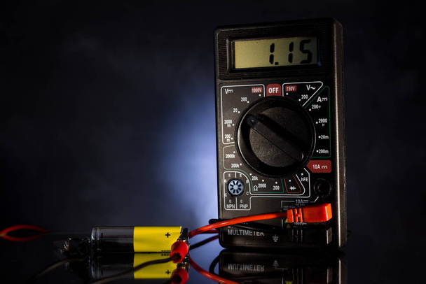 Instrument de mesure de l'énergie électrique ; vérifier la charge de la batterie sur un fond noir rétro-éclairé
. - Photo, image