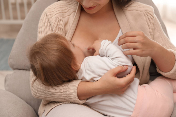 Γυναίκα θηλάζει το μωρό της στο σπίτι - Φωτογραφία, εικόνα
