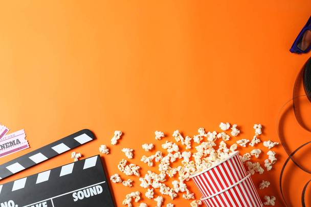 Flat lay composition with clapperboard and cinema tickets on orange background, space for text - 写真・画像