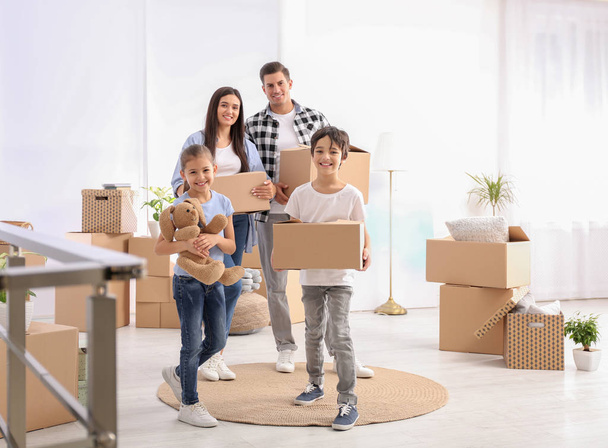 Happy family in room with cardboard boxes on moving day - Fotoğraf, Görsel