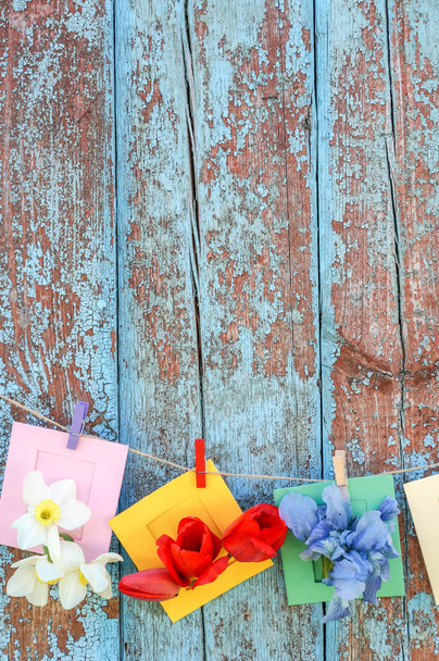 background with flowers in small envelop in grunge wooden wall - Photo, Image